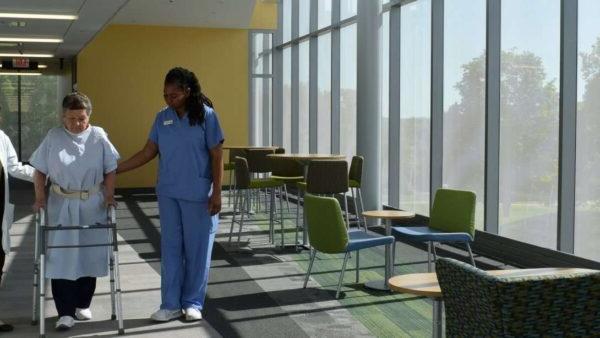 a nurse standing in a room with chairs and tables